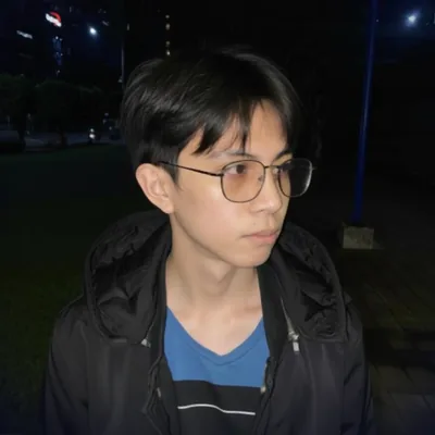 Alter, aka Marvin Aguinaldo, at night in a black jacket and glasses, looking off to the side